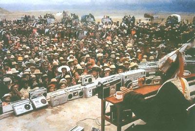 阿達在那曲賽馬會上說唱《格薩爾》，數千聽眾將他圍得水泄不通，大大小小的錄音機排成一排。本刊資料