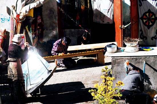 拉薩八廓街上，在昔日的“采爾廈”大院落里，居民們燒水、洗衣、做家具忙碌地生活。
