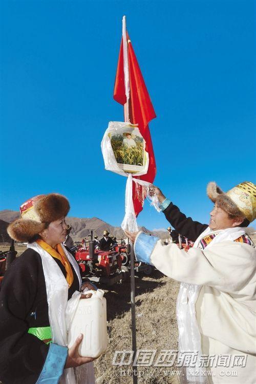 開耕儀式上，桑珠林村村民向領袖像敬獻潔白的哈達，祝福祖國繁榮昌盛。記者 旦增 攝