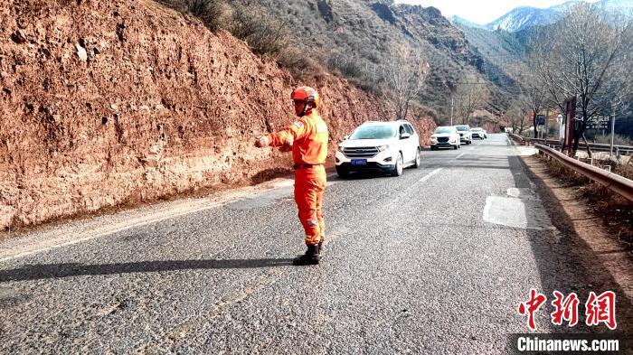 圖為昌都市卡若區(qū)森林消防中隊“火焰藍”志愿服務隊指揮過往車輛安全通行。　卡若區(qū)森林消防中隊“火焰藍”志愿服務隊供圖